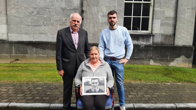 Ann Gorman holds a picture of her late son John, with John's father James and brother Adam when they attended the inquest in Tullamore