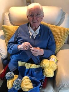 “I really wanted to do something for them and as I knit every day I decided to knit the little caps for them and in their country colours. My daughter Pam finished them of with the tossels. I also knitted little baby cardigans for them," she said.