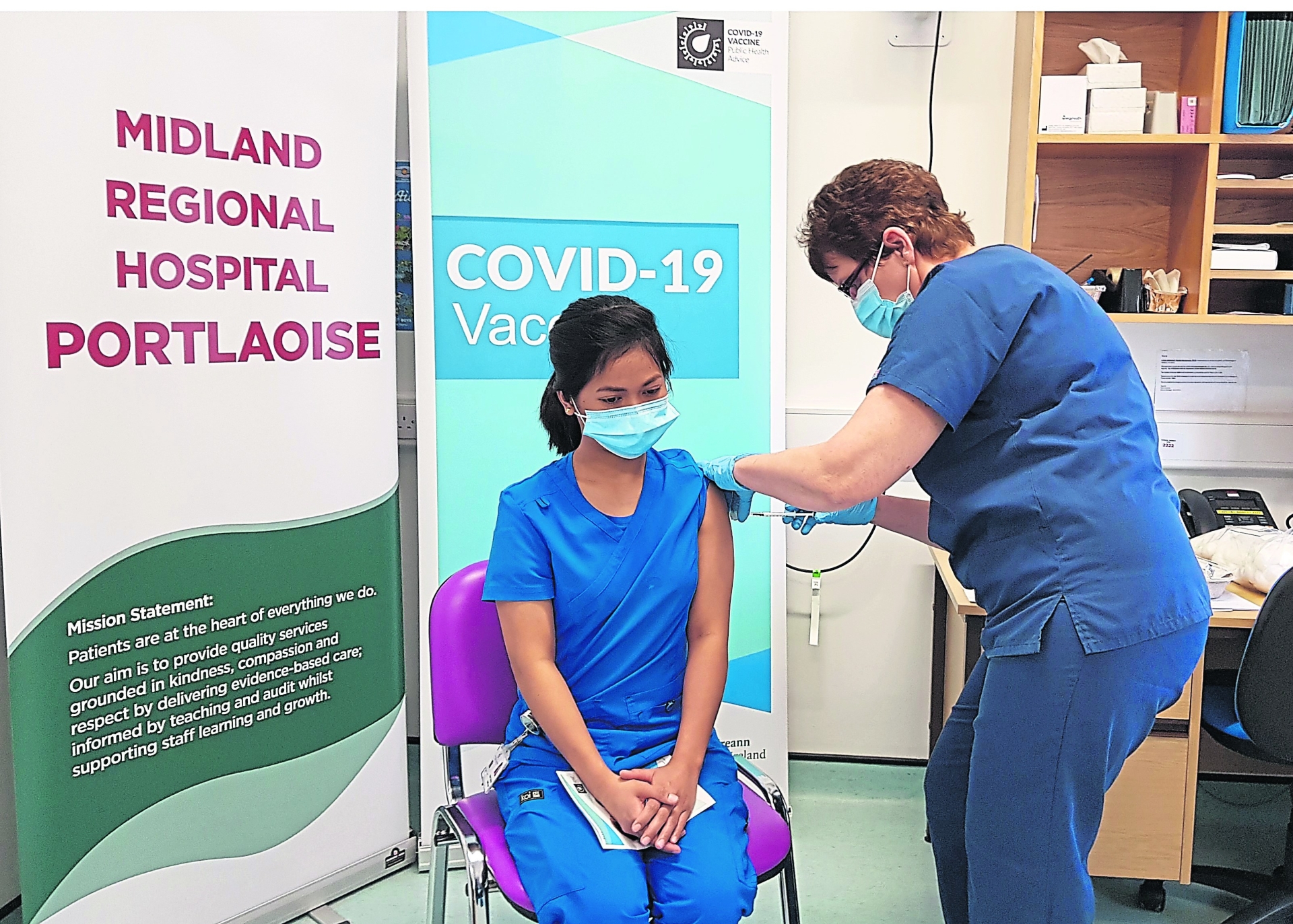 Aidel Aurel Casabar, staff nurse ED, is the first person in the Midland Regional Hospital Portlaoise to be vaccinated. She was vaccinated by Mary Gilligan, Clinical Placement Co-ordinator.