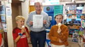 Aidan Byrnes with his certificate as the Leinster Express Readers' Choice Best '99 in Laois 2026, with happy young customers Adam Powala and Lucy O'Brien.