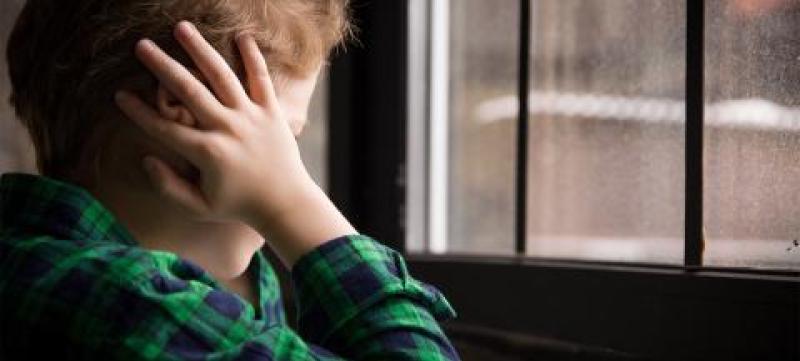 littleboystandingbehindthewindowinsadmood-1440