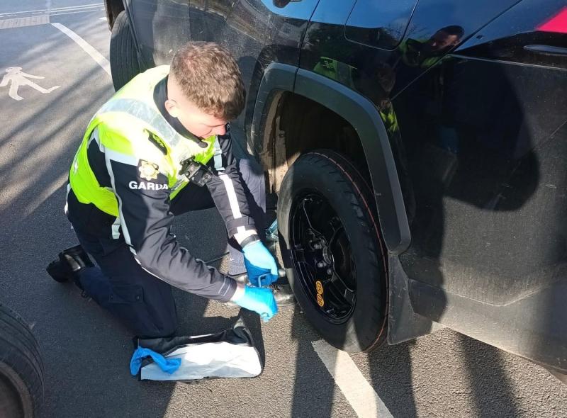 Garda Darren Garvey  changing a tyre. 