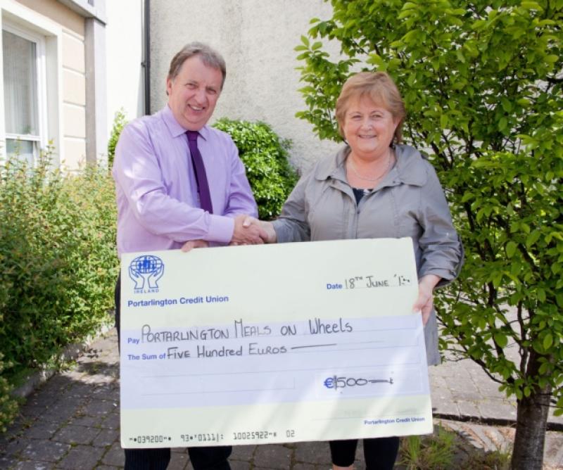 Michael McEvoy (manager of Port Credit Union ) presenting a cheque to Ann Dunne (chairperson of Port Meals on Wheels).