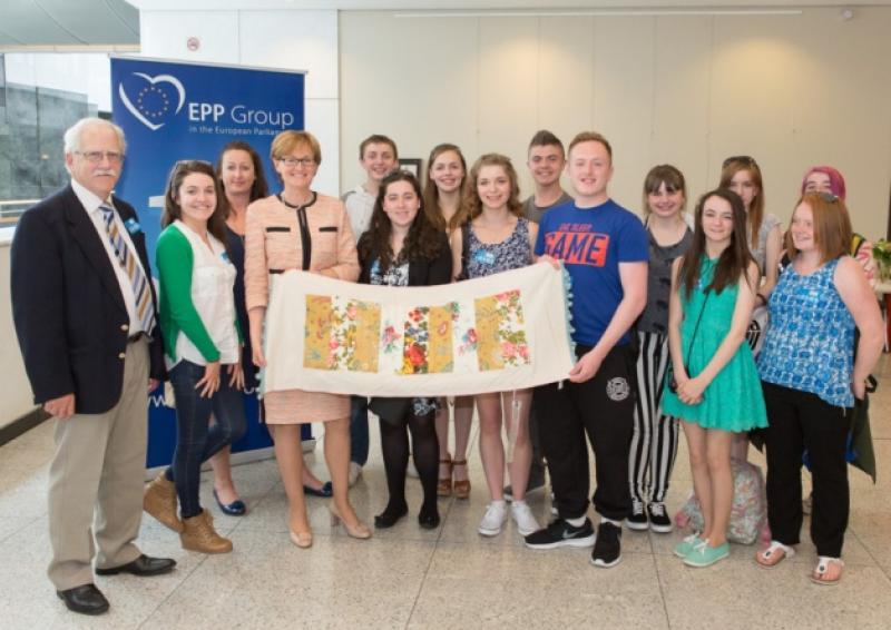 Mountmellick Youth Development Centre Teens Group and leaders presenting a locally handcrafted  table runner to MEP Mairead McGuinness during their visit to the European Parliament in June.