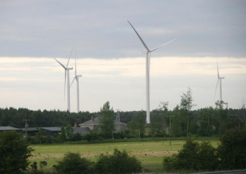Giant Wind Turbines rise behind forestry near Roscrea,