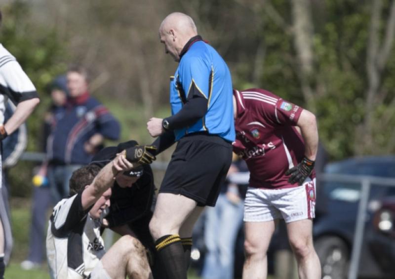 Shane Julian, Arles Killeen gets a lift from referee Joe Brennan against Arles Kilcruise in the ACFL at Killeen.Picture: Alf Harvey/hrphoto.ie