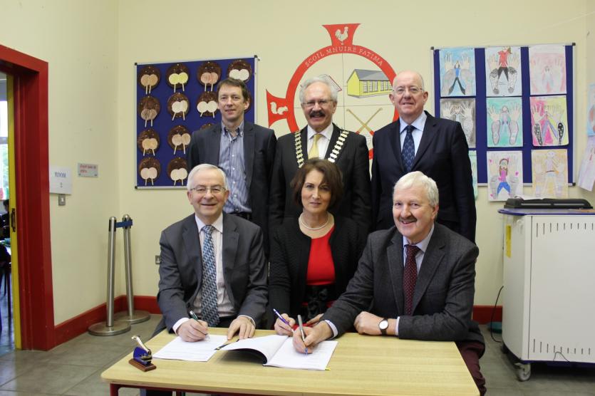 Principal Ann Bergin signing the contracts.